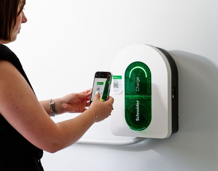 jeune femme scann le QR Code de sa borne de recharge sur son mobile