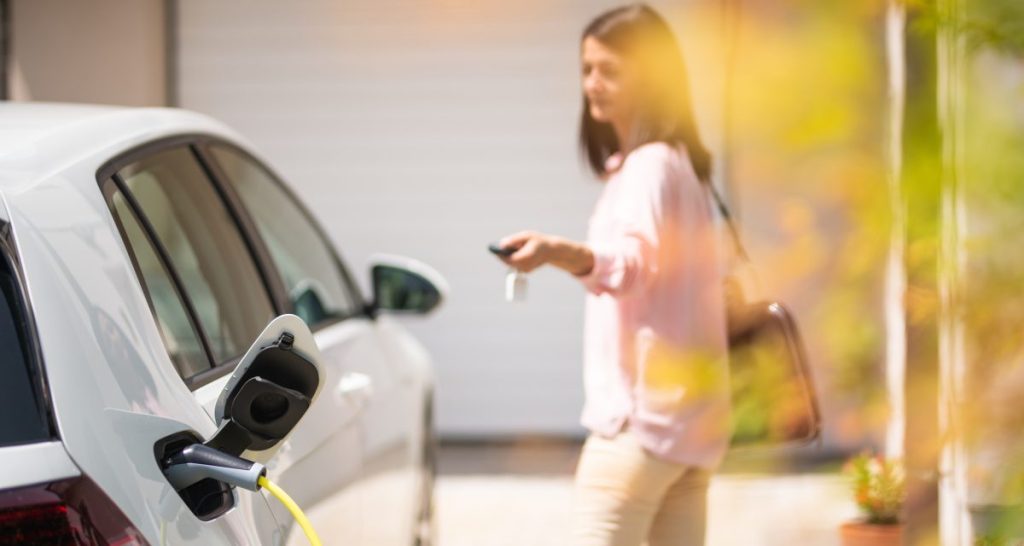 jeune femme recharge voiture electrique a domicile
